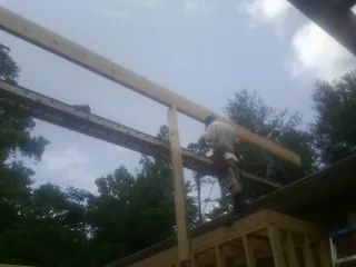 Carpenter setting a ridge beam over a new addition frame — Ice Dam Removal by Roofing Brothers in Port Edwards