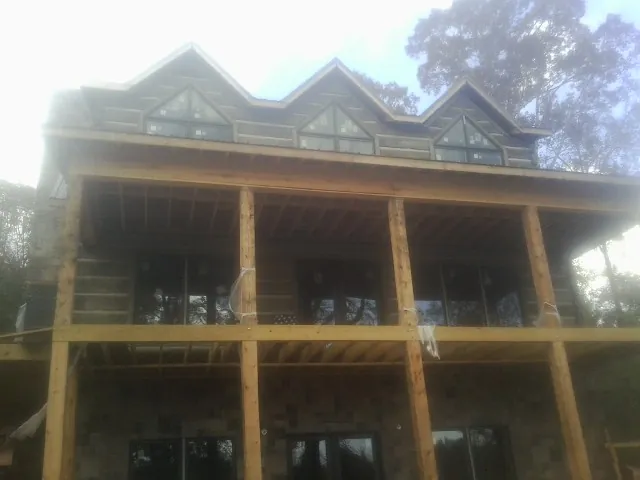 Dormers and porch framing on a large log home under construction — Roof Coating work by our crew in Port Edwards