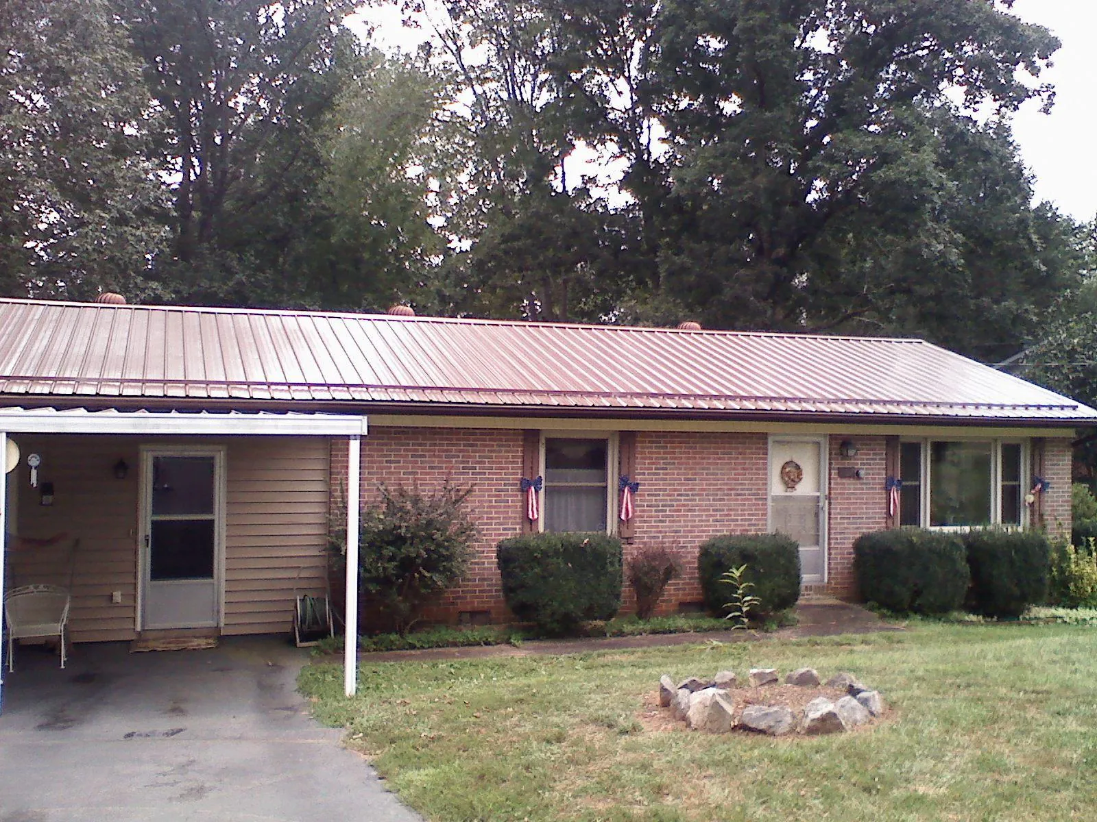 Bronze metal roof and carport on a brick ranch home in Port Edwards