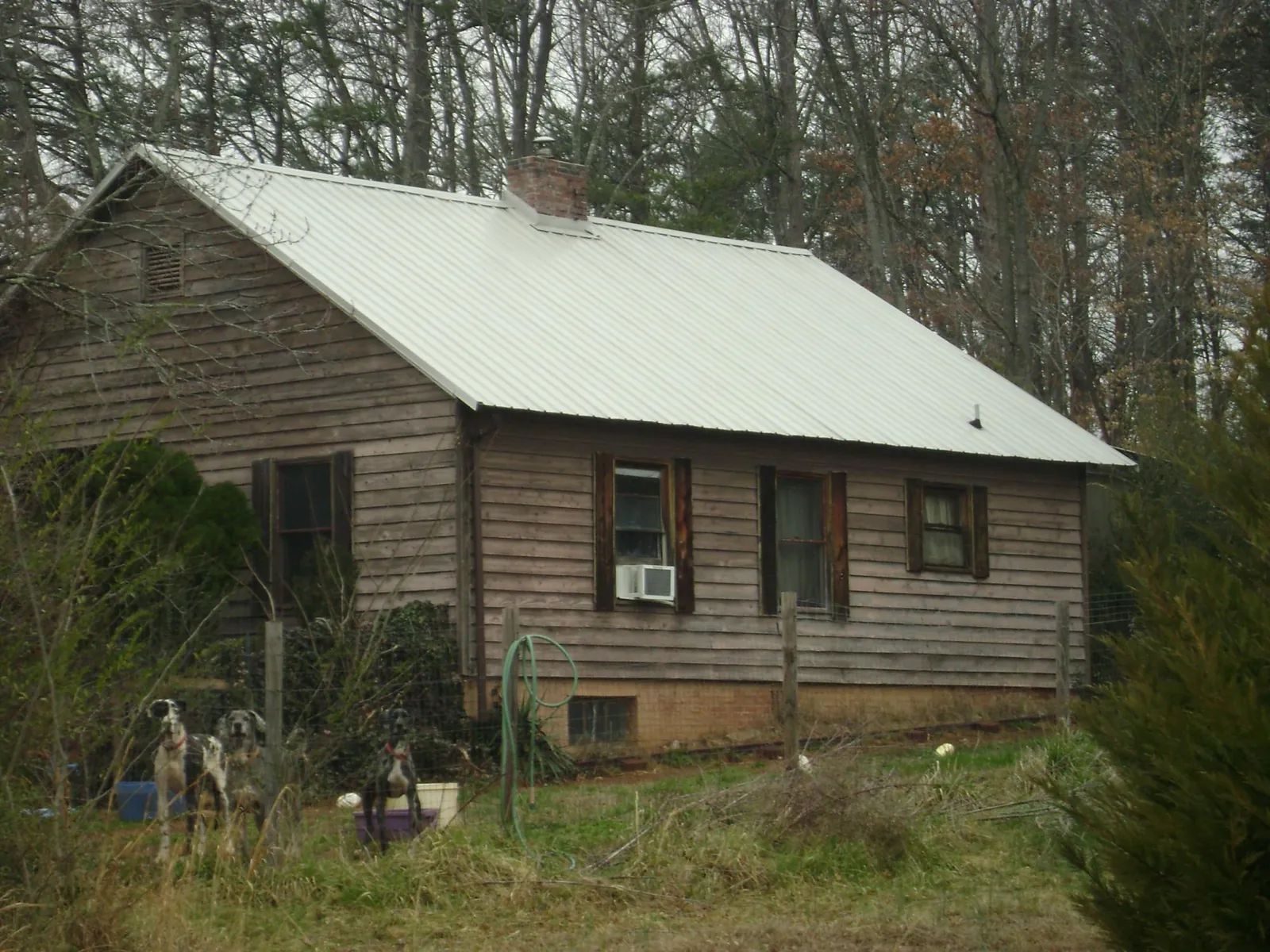 White metal roof on an old wood sided farmhouse, from a Metal Roof Installation job in Port Edwards